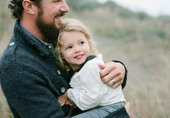 父親に抱きかかえられる少女