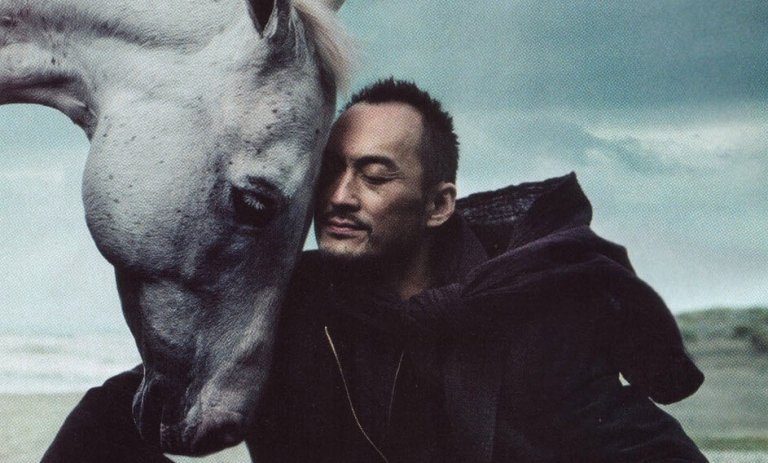 馬を抱きよせる男性