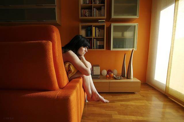 ソファでクッションを抱える女性