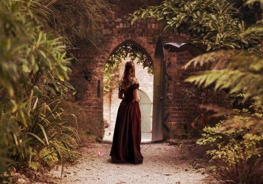 アーチ型のゲートの前に立つ女性