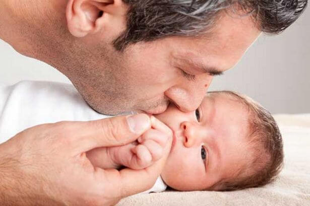 赤ちゃんにキスする父親