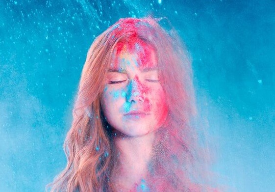 青い光の中で目を閉じる女性