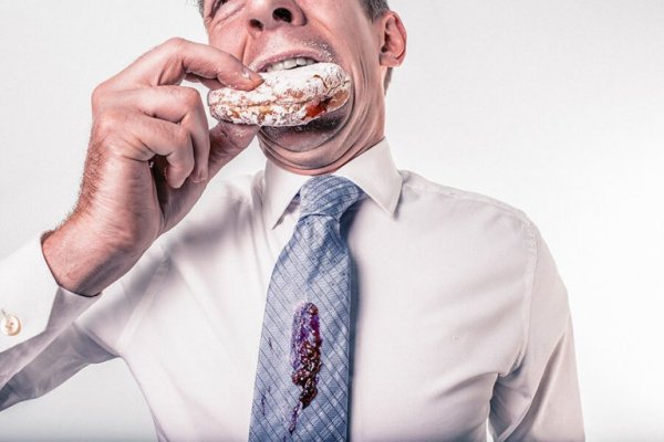 ネクタイを汚しながらドーナツを食べる