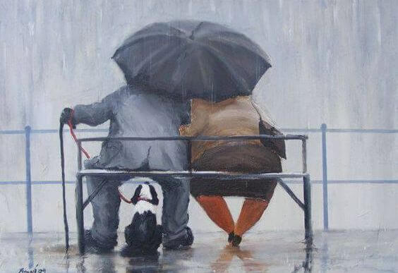 傘をさしてベンチに座る老夫婦