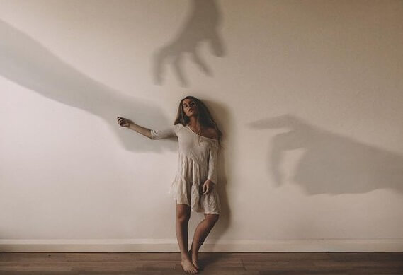 手の影に追われる女性