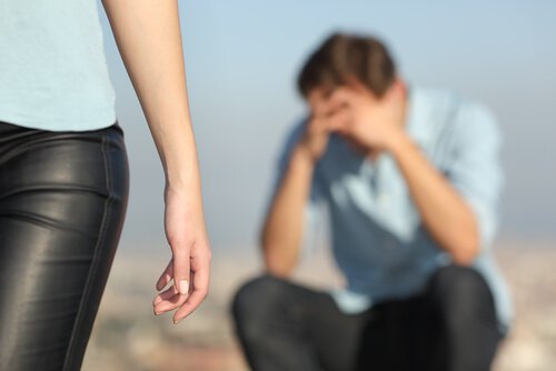 頭を抱える男性と立ち去る女性