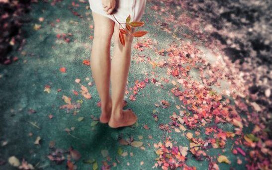 落ち葉を手にする裸足の女性