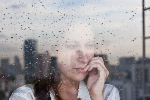 小雨の外を眺める女性