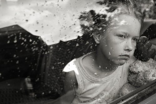 雨の日の外を眺める子供