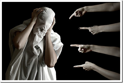 指をさされて顔を覆う人