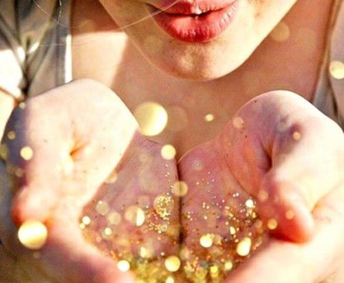 金粉を手から吹き飛ばす女性