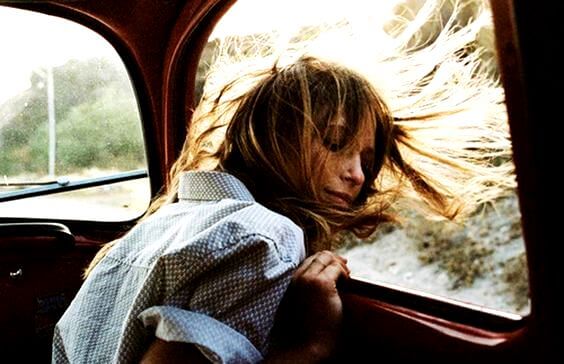 車の窓から頭をのぞかせる女性