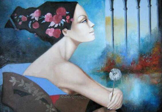 タンポポの綿毛を手に遠くを見つめる女性