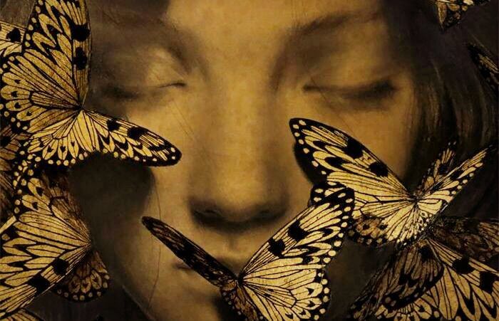 女性の顔に集まる蝶