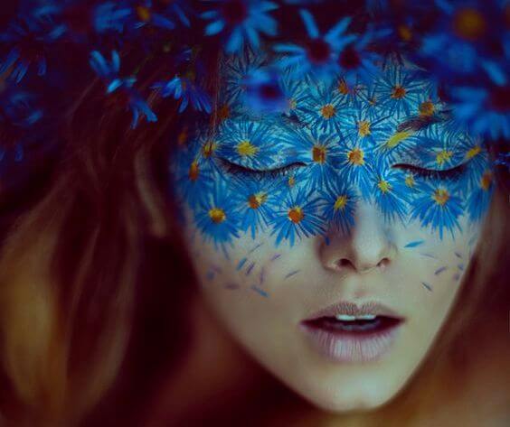顔に青い花が映る女性