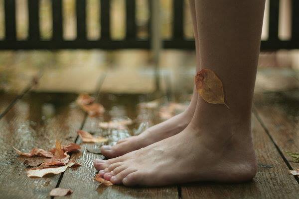 裸足の足と落ち葉