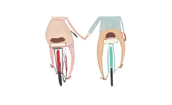 自転車に乗って手をつなぐ二人