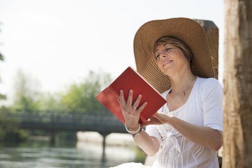 水辺で本を読む女性