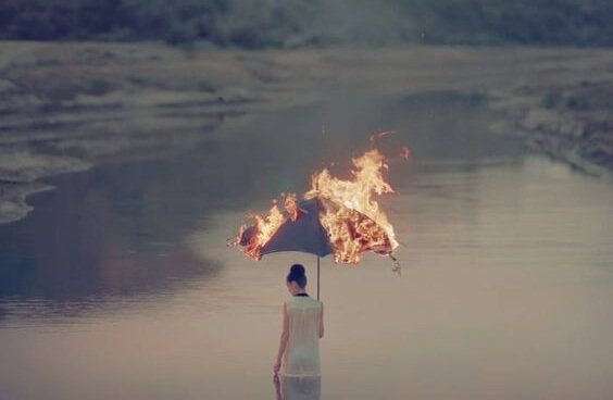 燃える傘をさす女性