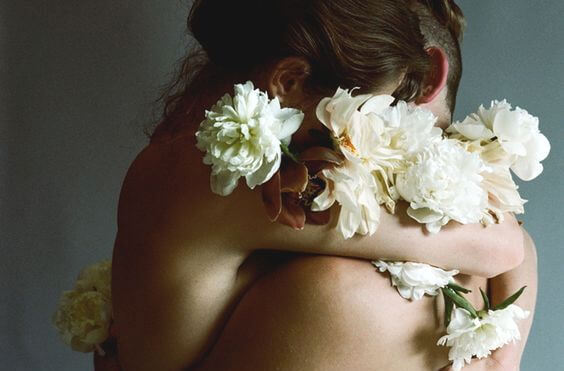 裸で抱き合う二人と白い花