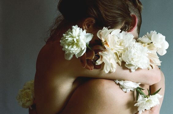 裸で抱き合う二人と白い花