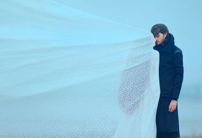 白いベールに包まれた女性の前に立つ男性