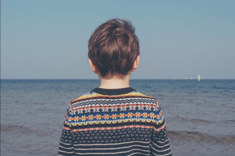 海を眺める子供の後ろ姿