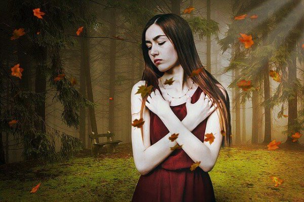 落ち葉の舞う森の女性