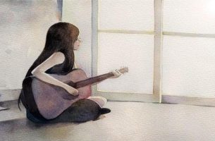 座ってギターを弾く女性