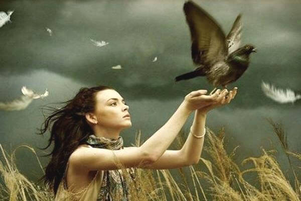 鳩を手に乗せる女性