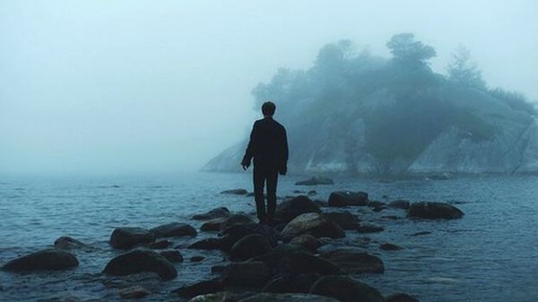 海の岩の上を歩く人
