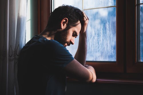 窓辺で悩む男性