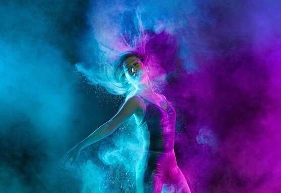 青と紫のライトを浴びて踊る女性