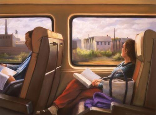 本を手に車窓を眺める女性