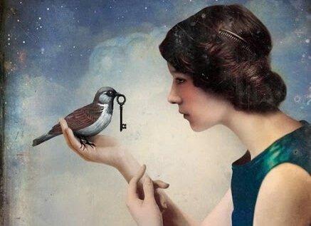 鍵をくわえた鳥が女性の手に乗っている