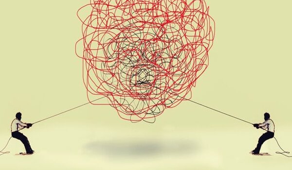 絡まった糸を引っ張る人