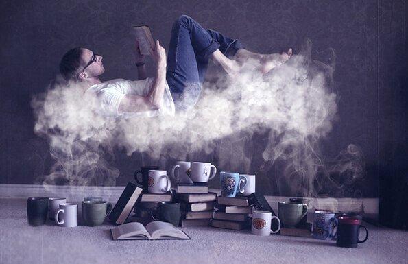 コーヒーの湯気の上で本を読む男性