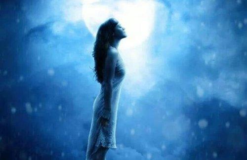 月の前に立つ女性