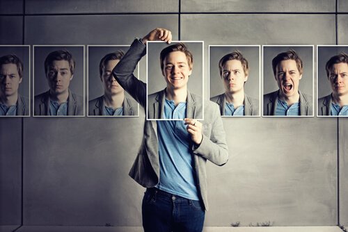 異なる表情のカードを持つ男性