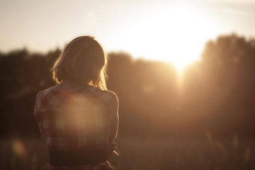 夕陽を見つめる悲しい女性