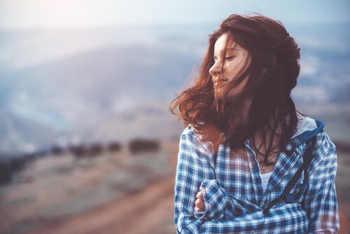 山で目を閉じる女性