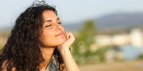 目を閉じて考える女性