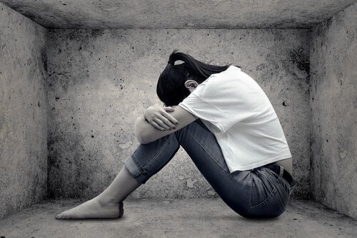 膝を抱える女性