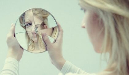 割れた鏡を見る女性